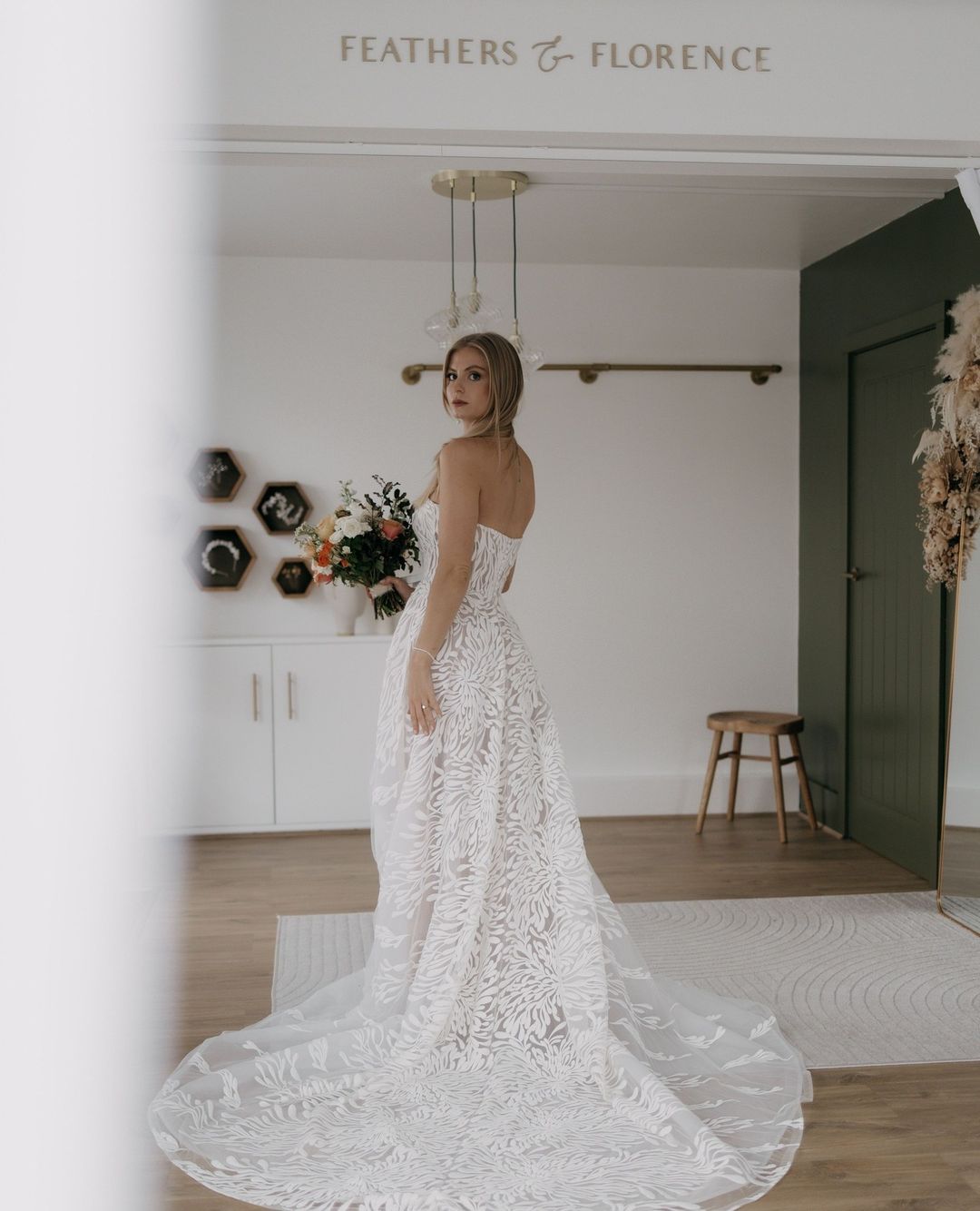 An A-Line silhouette with a straight, strapless neckline, Albina by Savin London.⁠ Feathers & Florence | Wedding Dress Preston